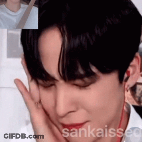 A Close Up Of A Person 'S Face With A Hand On Their Face GIF