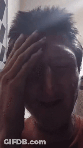 A Close Up Of A Person 'S Face With A Hand On Their Forehead GIF
