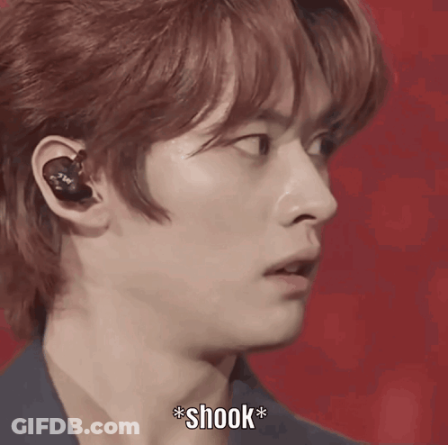 A Close Up Of A Person 'S Face With A Microphone And The Word Shook Below It GIF