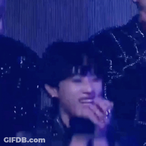 A Close Up Of A Person 'S Face With A Microphone In Their Hand . GIF