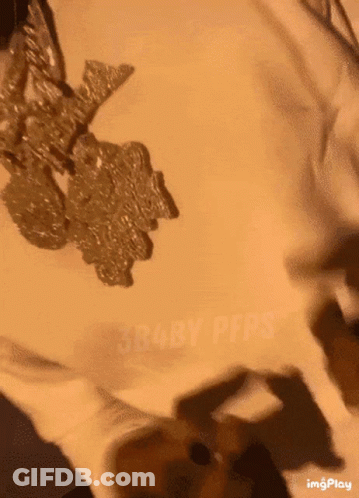 A Close Up Of A Person 'S Face With A Necklace On GIF