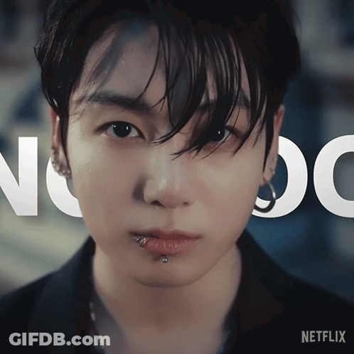 A Close Up Of A Person 'S Face With A Netflix Logo Behind Him GIF
