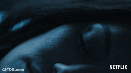A Close Up Of A Person 'S Face With A Netflix Logo Behind It GIF