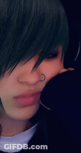 A Close Up Of A Person 'S Face With A Nose Ring And Earrings GIF