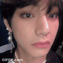 A Close Up Of A Person 'S Face With A Pearl Necklace . GIF