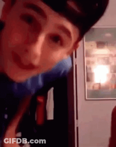 A Close Up Of A Person 'S Face With A Picture On The Wall In The Background . GIF