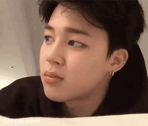 A Close Up Of A Person 'S Face With A Piercing In Their Ear And Earrings . GIF