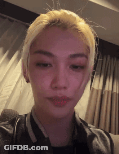 A Close Up Of A Person 'S Face With A Pink Background GIF
