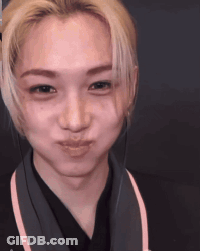 A Close Up Of A Person 'S Face With A Pink Stripe On The Collar GIF