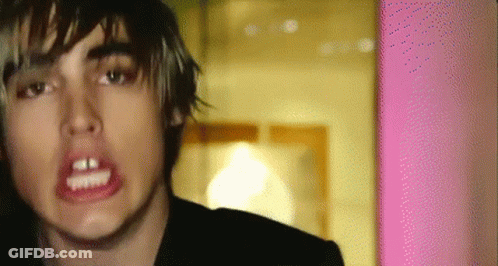 A Close Up Of A Person 'S Face With A Pink Wall In The Background GIF