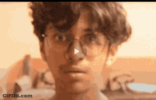 A Close Up Of A Person 'S Face With A Play Button On The Nose GIF