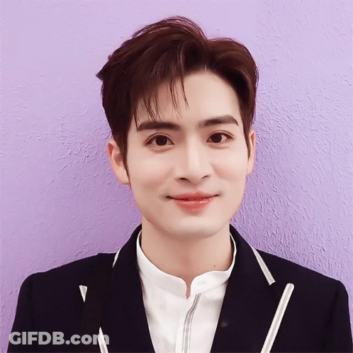 A Close Up Of A Person 'S Face With A Purple Wall In The Background GIF
