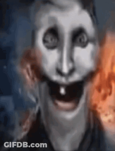 A Close Up Of A Person 'S Face With A Smiley Face And A Fire In The Background . GIF