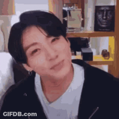 A Close Up Of A Person 'S Face With A Statue Of A Face In The Background . GIF