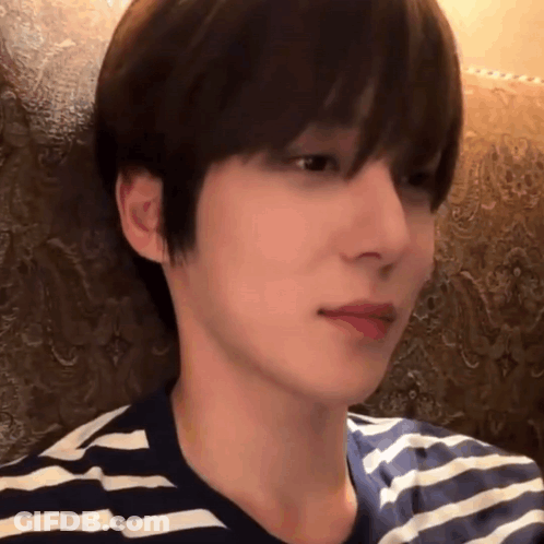A Close Up Of A Person 'S Face With A Striped Shirt On GIF
