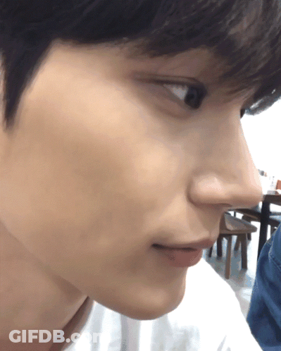 A Close Up Of A Person 'S Face With A Table And Chairs In The Background GIF