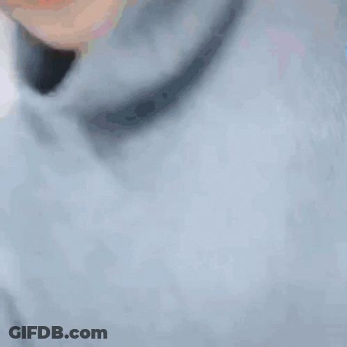 A Close Up Of A Person 'S Face With A Turtleneck And A Blue Shirt . GIF