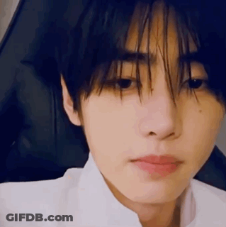 A Close Up Of A Person 'S Face With A White Shirt On And A Black Background . GIF