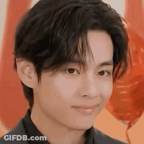 A Close Up Of A Person 'S Face With Balloons In The Background And A Smile On Their Face . GIF