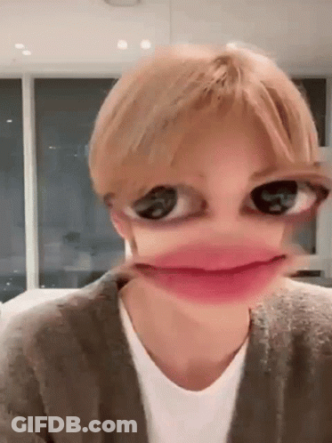 A Close Up Of A Person 'S Face With Big Eyes And A Pink Lip . GIF