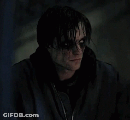 A Close Up Of A Person 'S Face With Black Eyes And A Black Jacket On . GIF