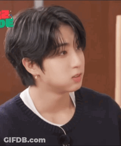 A Close Up Of A Person 'S Face With Black Hair And A White Shirt . GIF