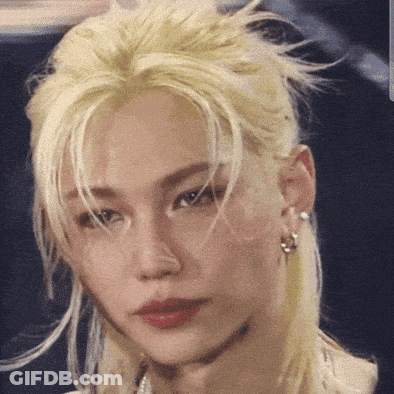 A Close Up Of A Person 'S Face With Blonde Hair And Earrings GIF