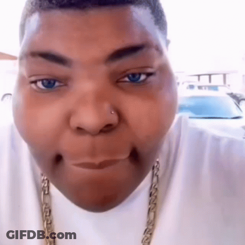 A Close Up Of A Person 'S Face With Blue Eyes And A Gold Chain Around Their Neck GIF