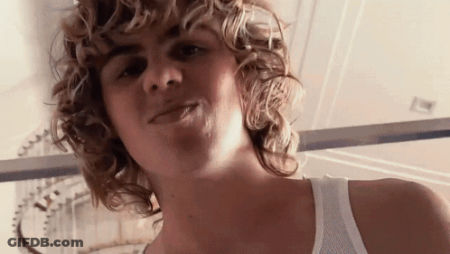 A Close Up Of A Person 'S Face With Curly Hair GIF