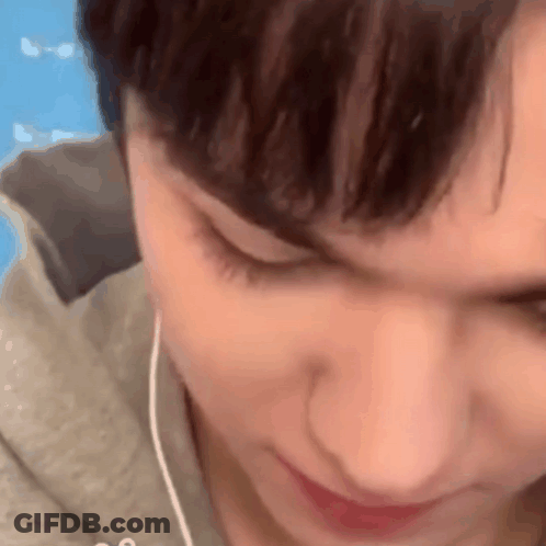 A Close Up Of A Person 'S Face With Earphones In Their Ears . GIF