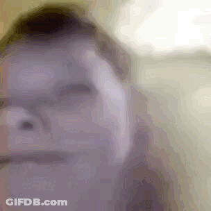 A Close Up Of A Person 'S Face With Glasses And A Blurred Background . GIF