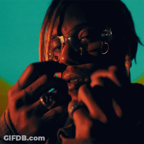 A Close Up Of A Person 'S Face With Glasses And Rings On Their Fingers GIF