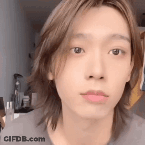 A Close Up Of A Person 'S Face With Long Hair And A Pink Lip . GIF