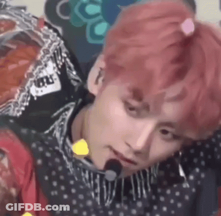 A Close Up Of A Person 'S Face With Pink Hair And A Microphone In Their Mouth . GIF