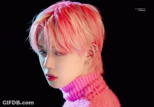 A Close Up Of A Person 'S Face With Pink Hair And A Pink Sweater GIF