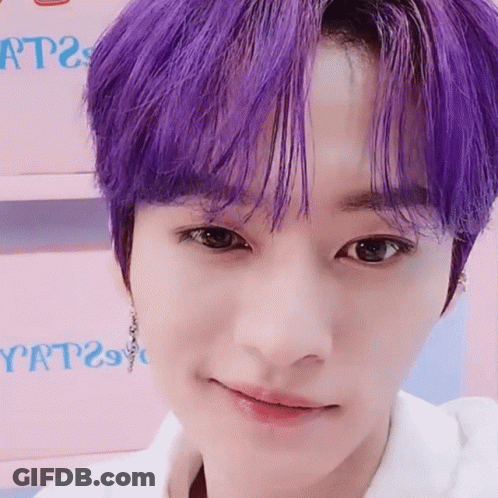 A Close Up Of A Person 'S Face With Purple Hair And A White Shirt . GIF