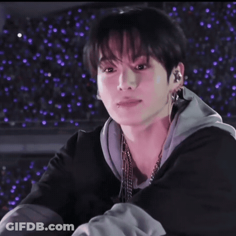 A Close Up Of A Person 'S Face With Purple Lights Behind Them . GIF