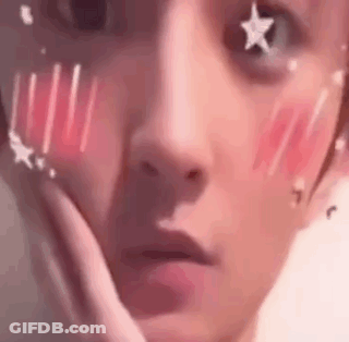 A Close Up Of A Person 'S Face With Stars On It And A Hand On Their Face . GIF