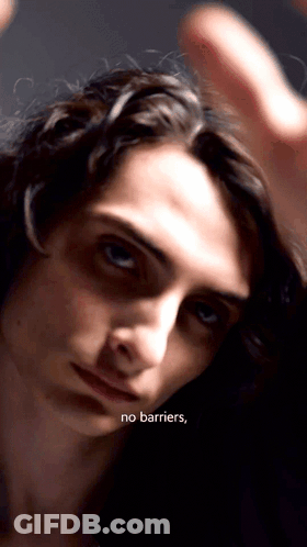A Close Up Of A Person 'S Face With The Words " No Barriers " Written Below It GIF