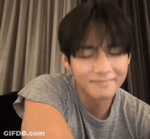 A Close Up Of A Person 'S Face With Their Eyes Closed And A T-Shirt On . GIF