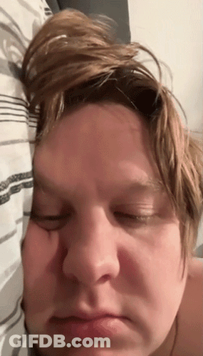 A Close Up Of A Person 'S Face With Their Eyes Closed And Their Hair Blowing In The Wind GIF