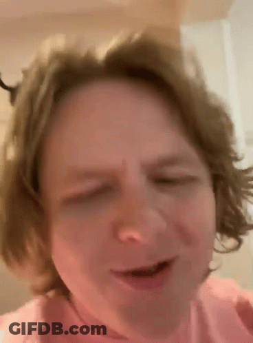 A Close Up Of A Person 'S Face With Their Eyes Closed And Their Hair Blowing In The Wind . GIF