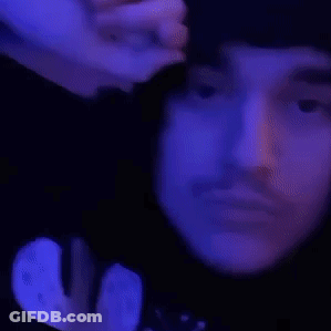 A Close Up Of A Person 'S Face With Their Eyes Closed And Their Hand On Their Forehead . GIF
