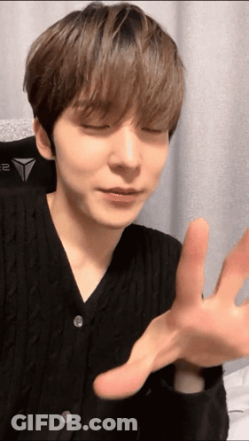 A Close Up Of A Person 'S Face With Their Eyes Closed And Their Hands Outstretched GIF