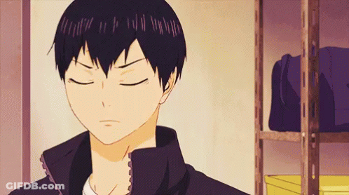 A Close Up Of A Person 'S Face With Their Eyes Closed In Front Of A Shelf . GIF
