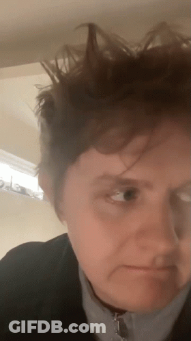 A Close Up Of A Person 'S Face With Their Hair Blowing In The Wind . GIF