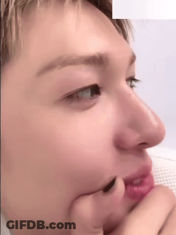 A Close Up Of A Person 'S Face With Their Hand On Their Face . GIF