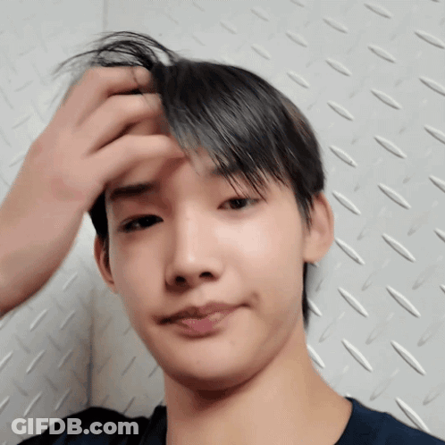 A Close Up Of A Person 'S Face With Their Hand On Their Forehead GIF