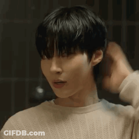 A Close Up Of A Person 'S Face With Their Hand On Their Hair . GIF