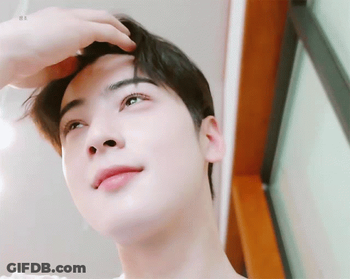 A Close Up Of A Person 'S Face With Their Hand On Their Head . GIF